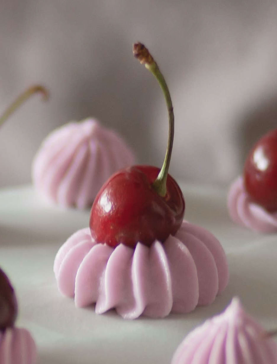 photo of Cherries on top of an iced cake