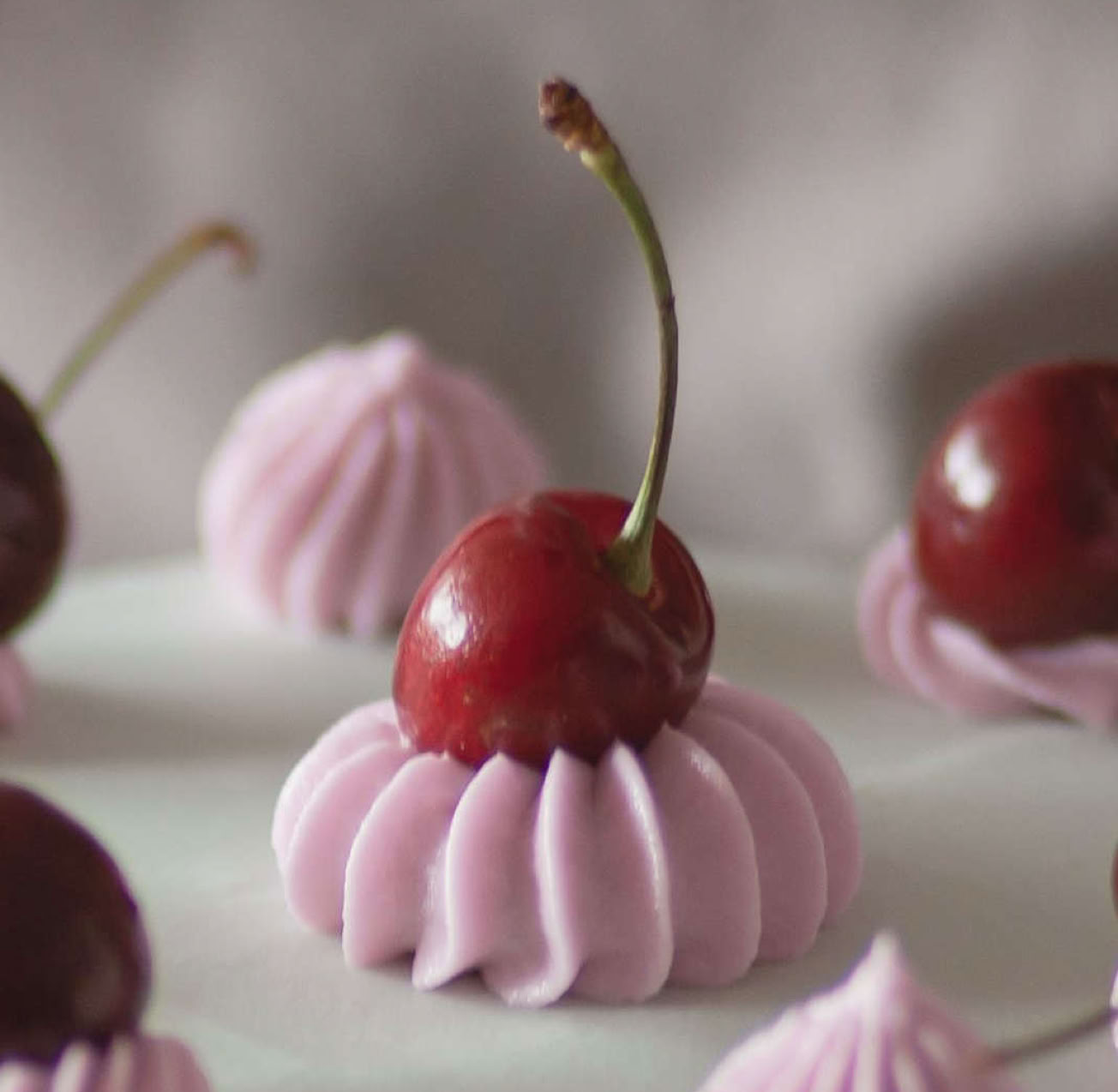 photo of Cherries on top of an iced cake
