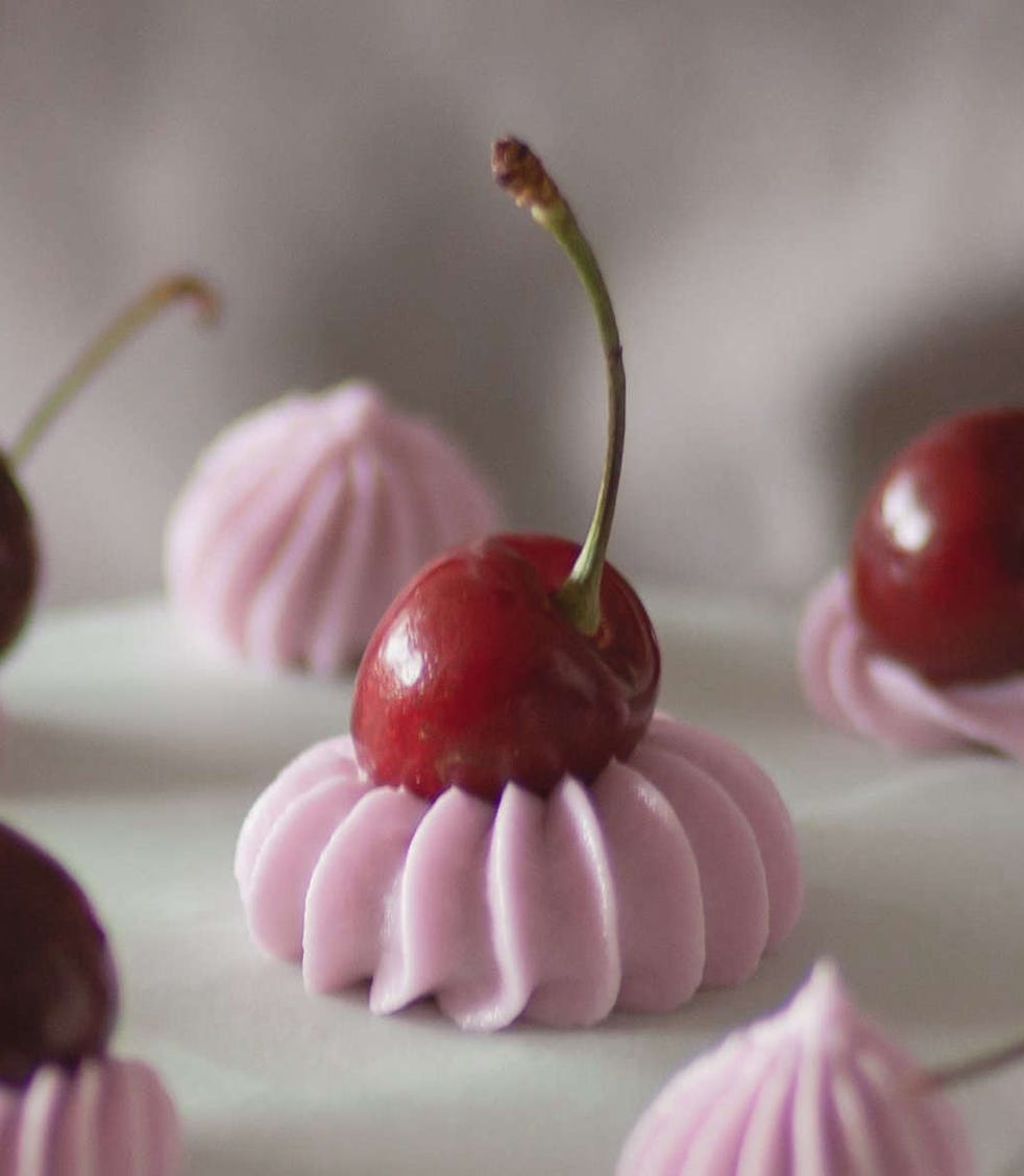 photo of Cherries on top of an iced cake